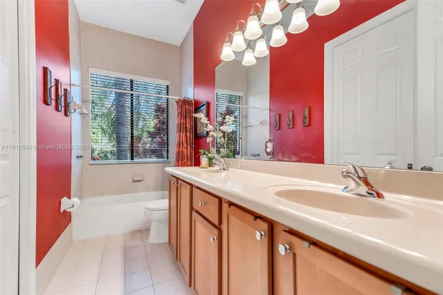 a bathroom with a sink a vanity a mirror a bathtub and a large mirror