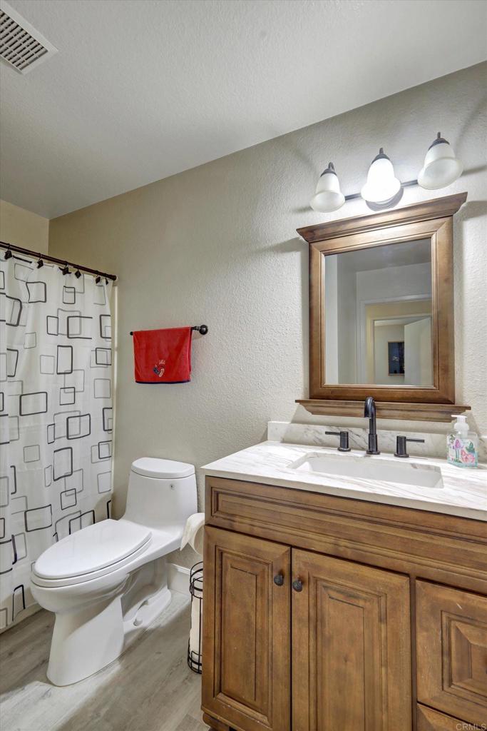 108 Blue Ash Court Encinitas, CA 92024 - Photo 14 of 35 a bathroom with a sink a toilet a mirror and shower curtain
