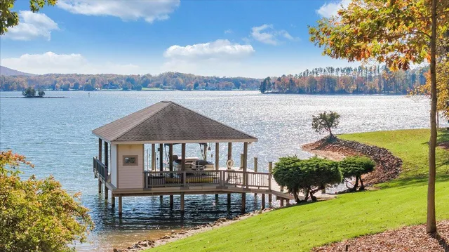 a front view of a house with garden and trees