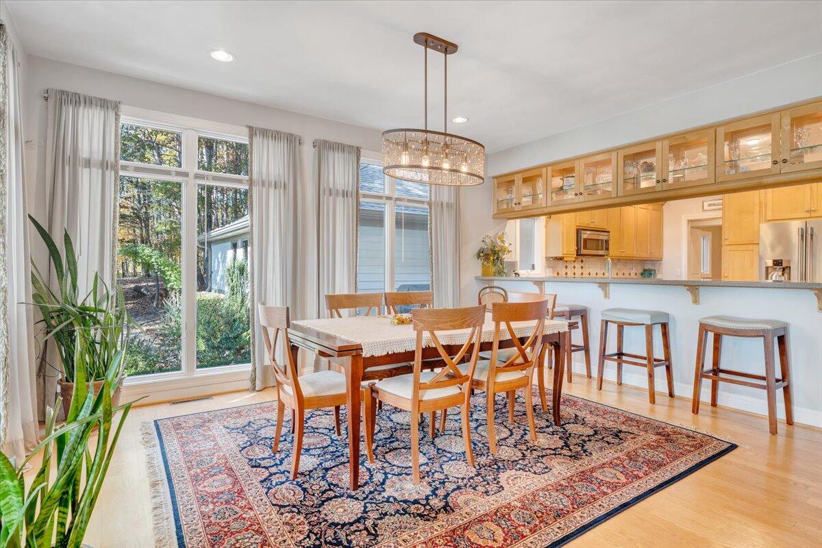 190 Tranquility Road Moneta, VA 24121 - Photo 30 of 170 a dining room with wooden floor a chandelier a wooden table and chairs