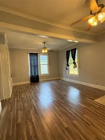 a view of an empty room and window and wooden floor