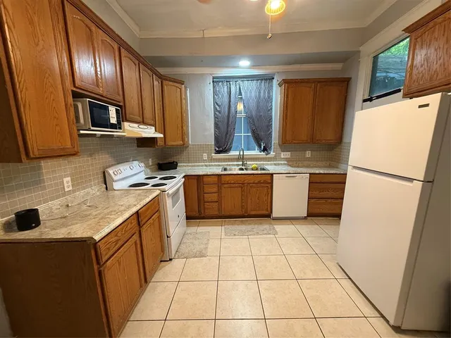 a kitchen with stainless steel appliances granite countertop a sink stove refrigerator and cabinets