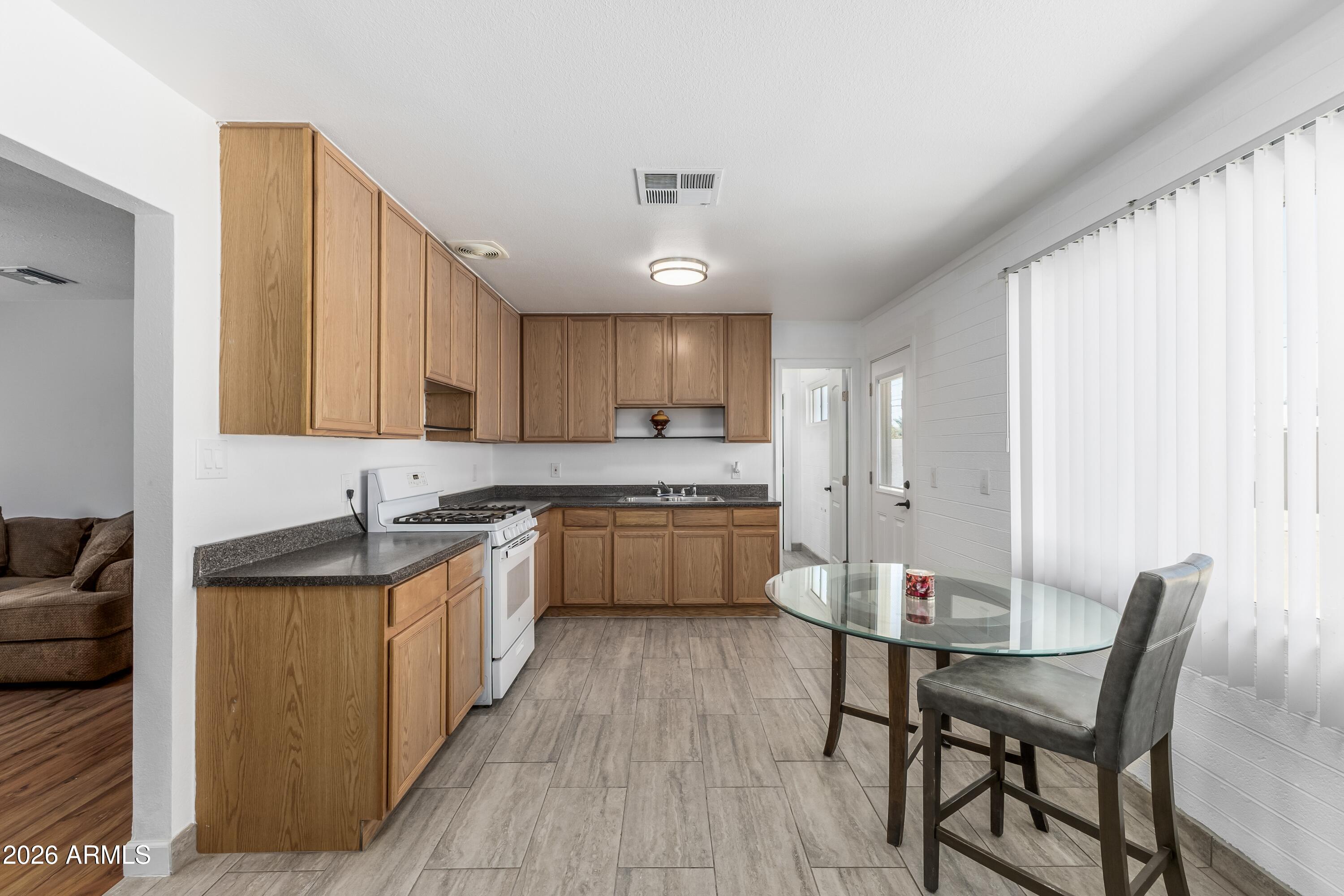 3137 North 37th Drive Phoenix, AZ 85019 - Photo 4 of 18 a kitchen with a table chairs microwave and cabinets