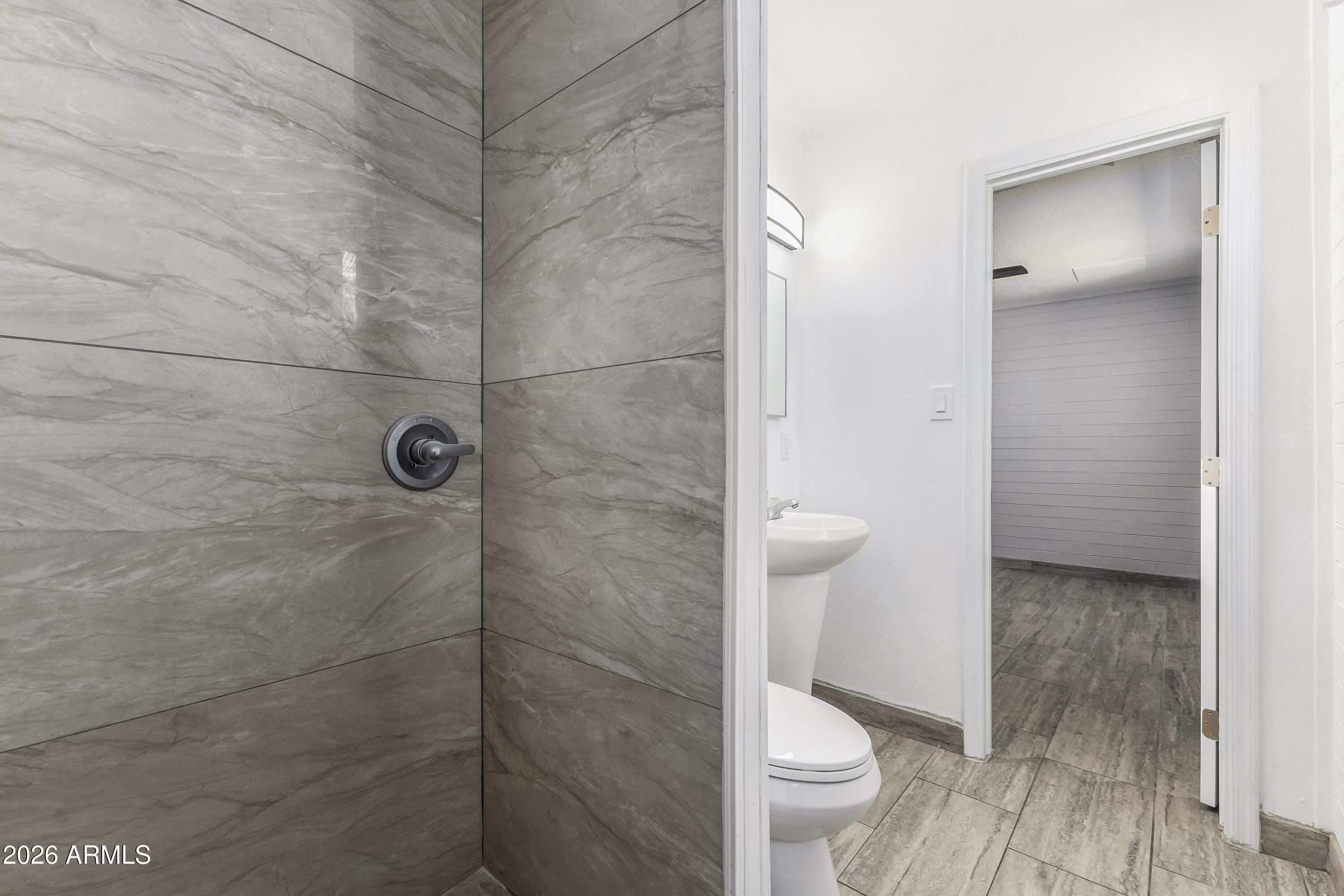 3137 North 37th Drive Phoenix, AZ 85019 - Photo 8 of 18 a bathroom with a granite countertop shower and a toilet