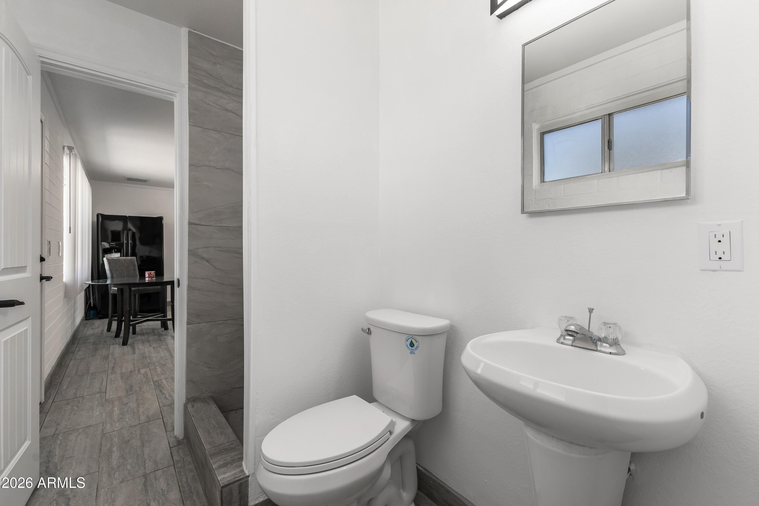 3137 North 37th Drive Phoenix, AZ 85019 - Photo 9 of 18 a white toilet sitting next to a bathroom sink