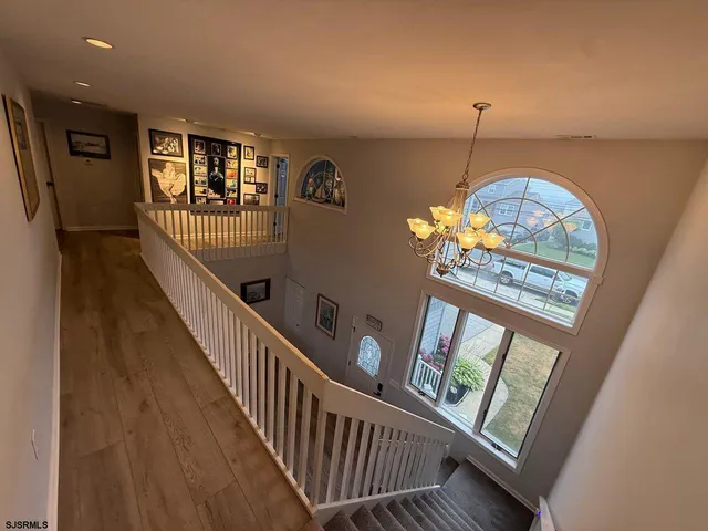 a view of a hallway with wooden floor and windows