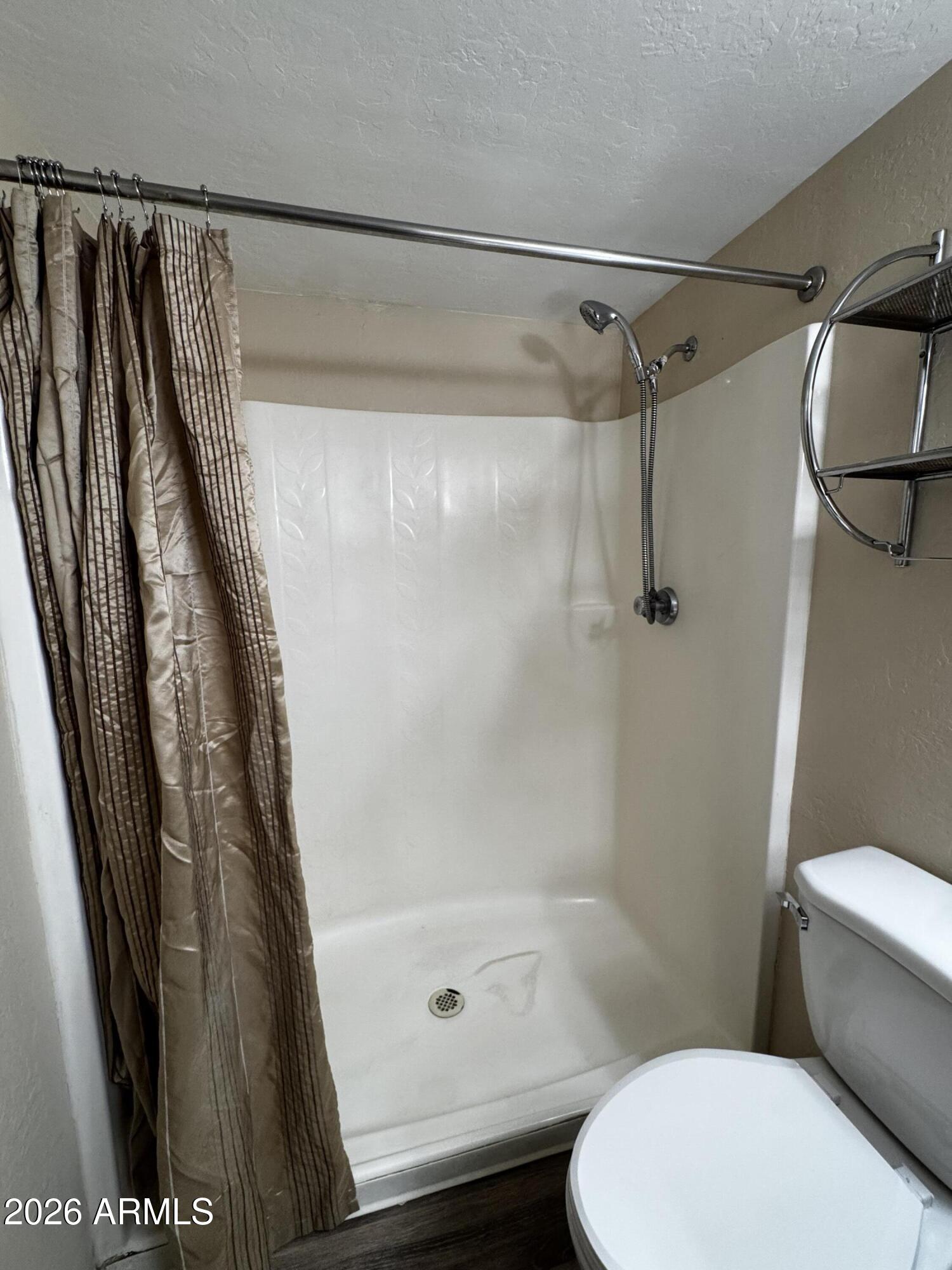 12123 West Bell Road, Unit 258 Surprise, AZ 85378 - Photo 11 of 30 a bathroom with a shower a toilet and a shower