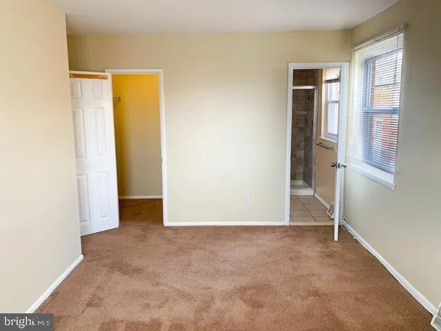 an empty room with windows and closet