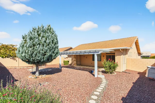 a front view of a house with a yard and potted plants