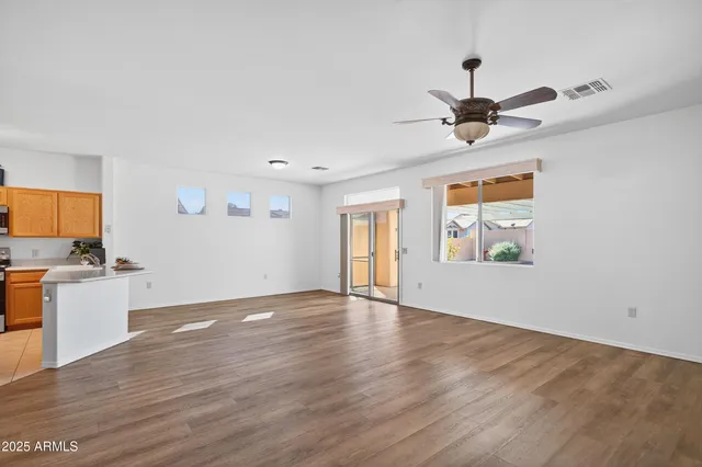 a view of an empty room with window and wooden floor