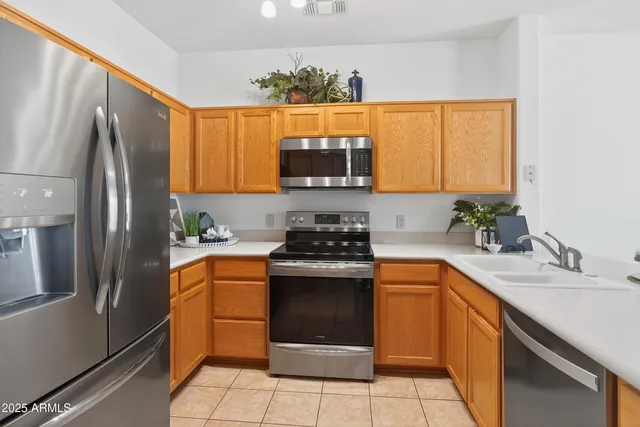 a kitchen with stainless steel appliances granite countertop a stove a sink and a refrigerator