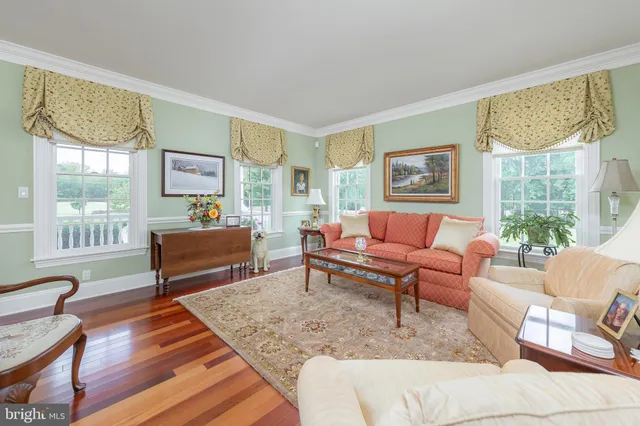 a kitchen with stainless steel appliances granite countertop a stove top oven a sink dishwasher and a refrigerator with wooden floor