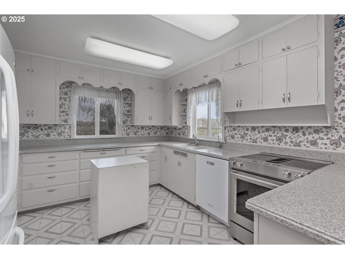 23990 Southwest Tile Flat Road Hillsboro, OR 97123 - Photo 7 of 46 a kitchen with granite countertop white cabinets and white appliances