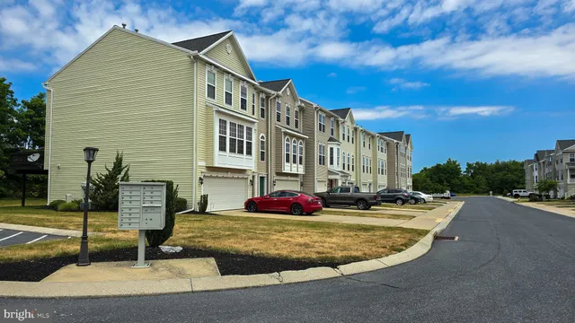 a view of a house with a big yard and large trees