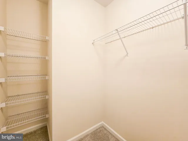 an empty room with a chandelier fan and windows