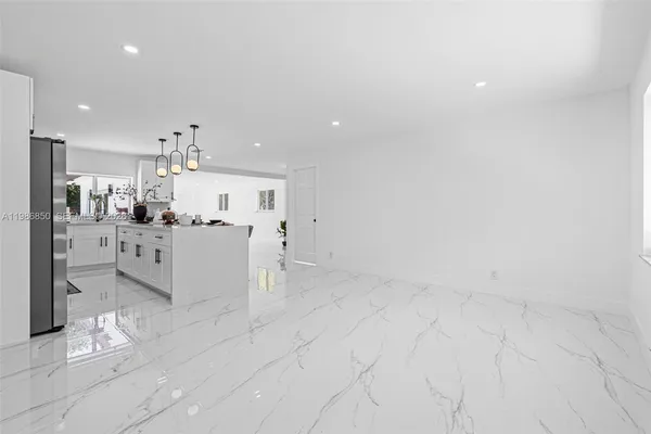 a kitchen with stainless steel appliances granite countertop a refrigerator and a stove top oven