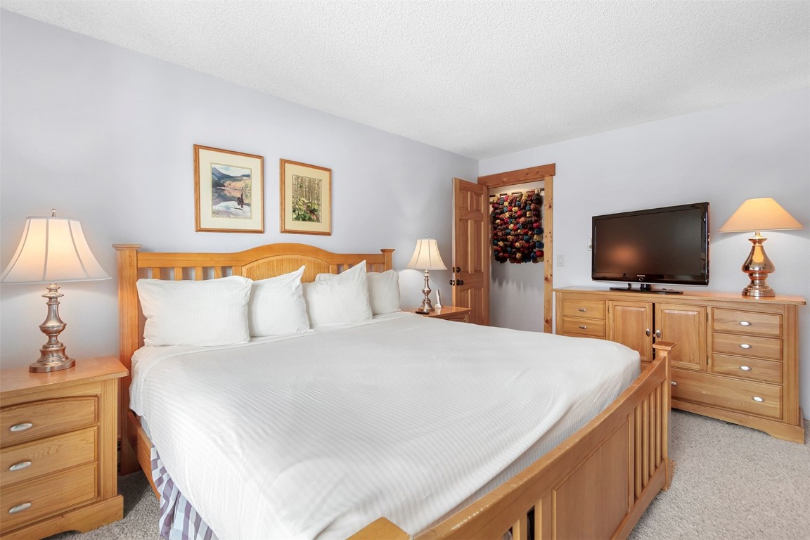 405 4 O Clock Road, Unit 12B Breckenridge, CO 80424 - Photo 12 of 27 a bedroom with a bed and a flat screen tv