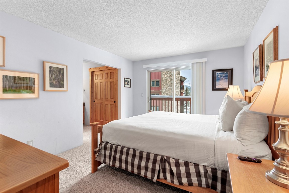 405 4 O Clock Road, Unit 12B Breckenridge, CO 80424 - Photo 13 of 27 a bedroom with a bed and wooden floor