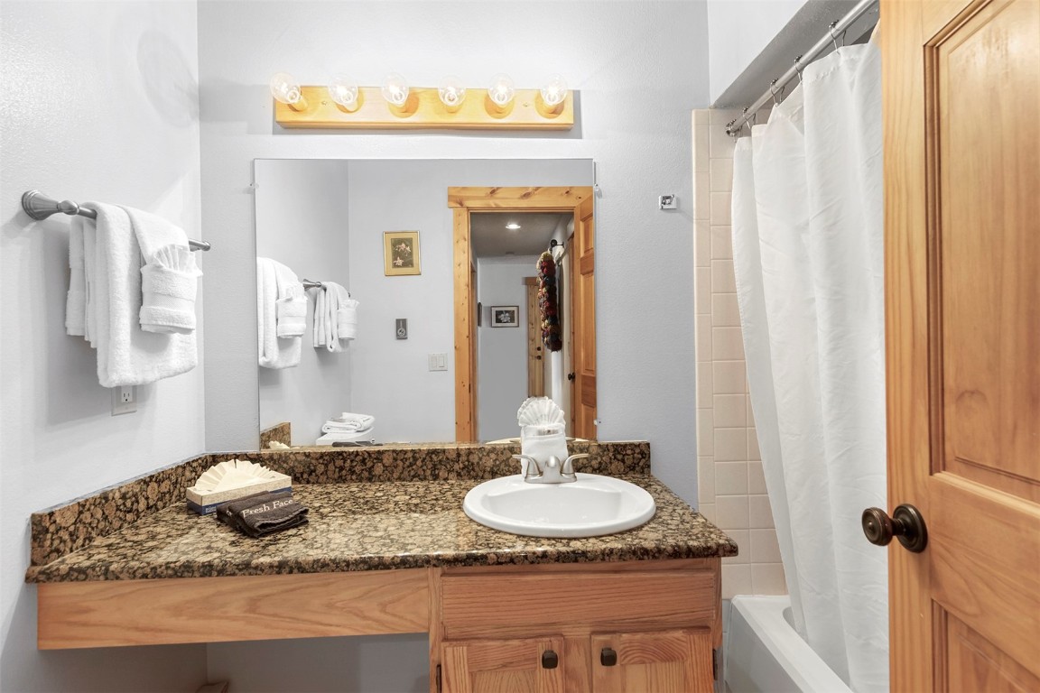 405 4 O Clock Road, Unit 12B Breckenridge, CO 80424 - Photo 17 of 27 a bathroom with a granite countertop sink and a mirror