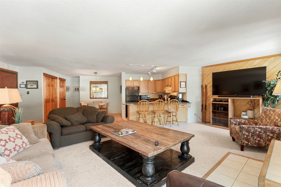 405 4 O Clock Road, Unit 12B Breckenridge, CO 80424 - Photo 6 of 27 a living room with furniture and a flat screen tv
