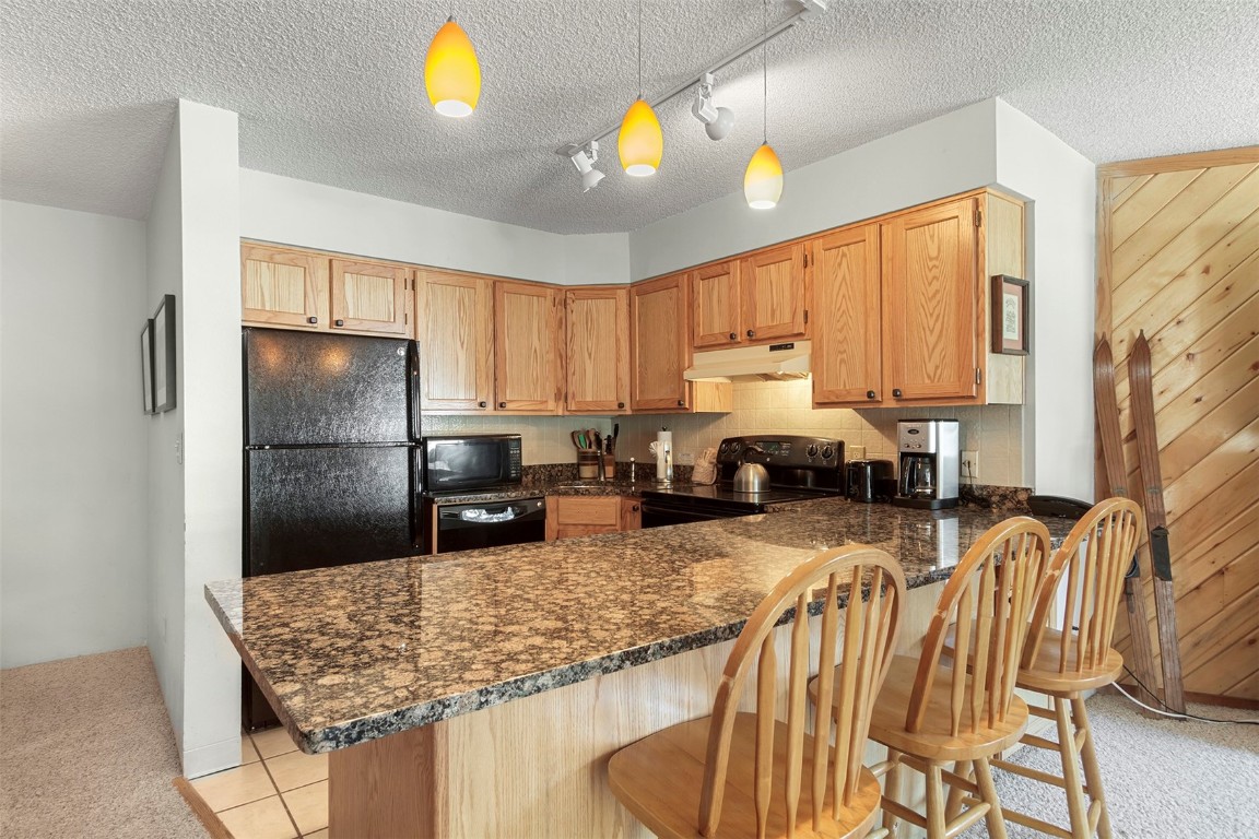 405 4 O Clock Road, Unit 12B Breckenridge, CO 80424 - Photo 7 of 27 a kitchen with stainless steel appliances granite countertop a sink refrigerator and cabinets