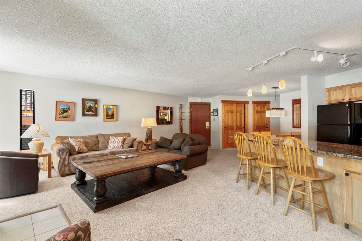 405 4 O Clock Road, Unit 12B Breckenridge, CO 80424 - Photo 8 of 27 a living room with furniture and a flat screen tv