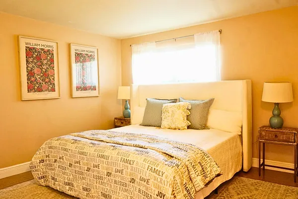 a large bed in a bedroom next to a window