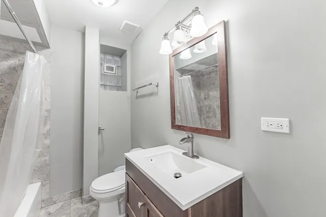 a bathroom with a sink toilet and shower