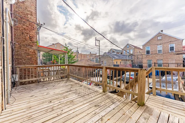 a view of a balcony with wooden floor and fence
