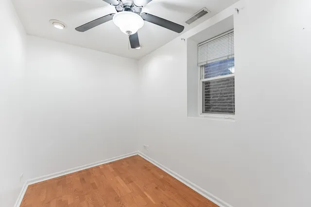 an empty room with a window and a fan