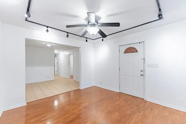 an empty room with closet and a chandelier fan