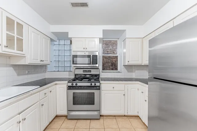 a kitchen with cabinets appliances and a counter space