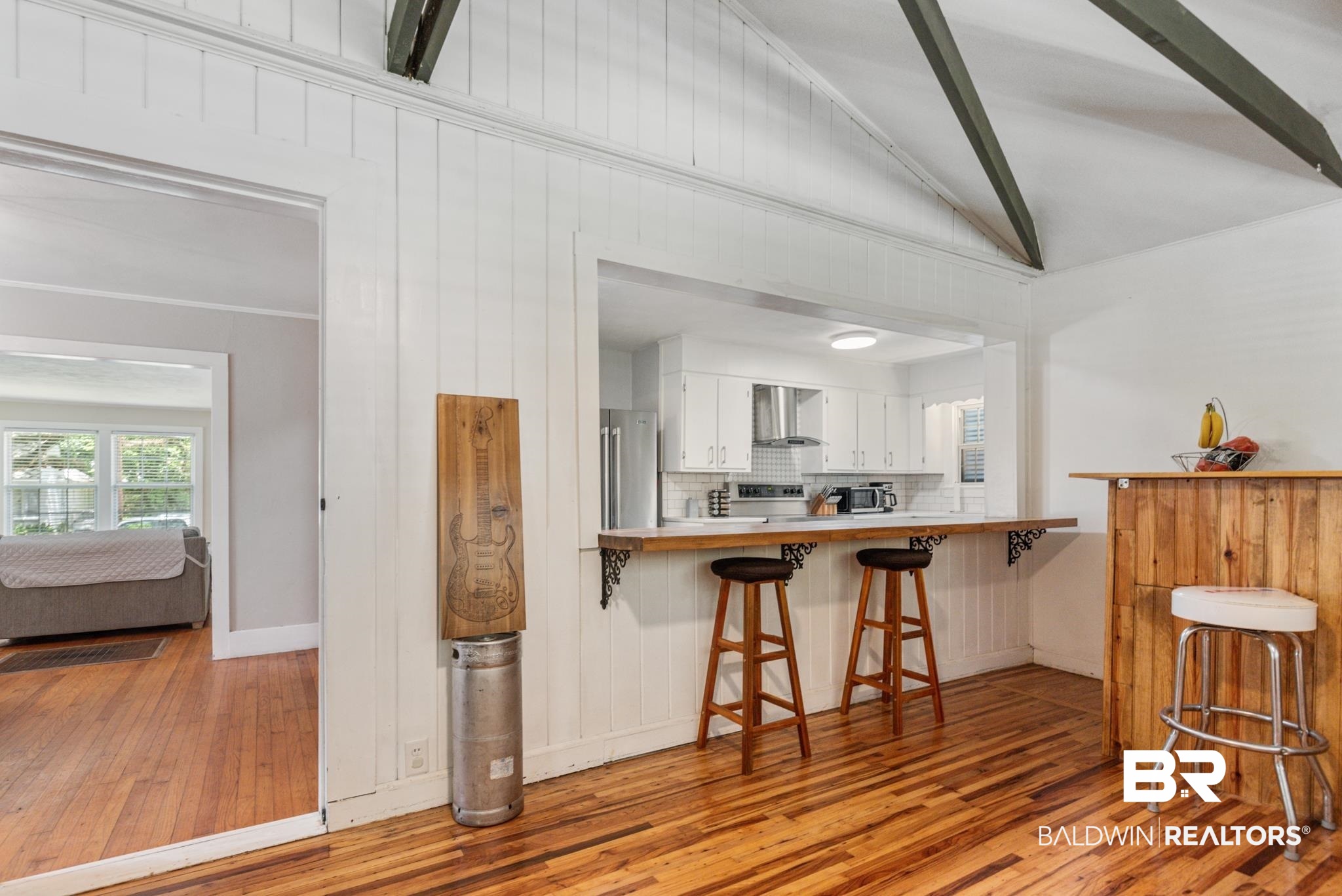 114 Crenshaw Street Mobile, AL 36606 - Photo 21 of 49 Kitchen with white cabinetry, a breakfast bar, kitchen peninsula, wall chimney range hood, and light hardwood / wood-style floors