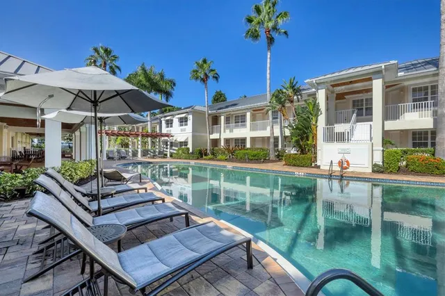a view of a patio with couches table and chairs under an umbrella