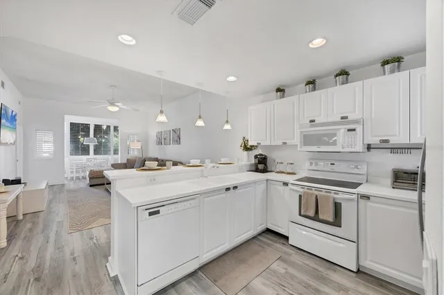 a kitchen with white cabinets and white appliances