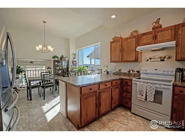 a kitchen with stainless steel appliances granite countertop a stove a sink dishwasher and white cabinets with wooden floor