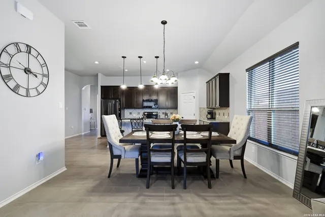 a living room with furniture a chandelier and a flat screen tv
