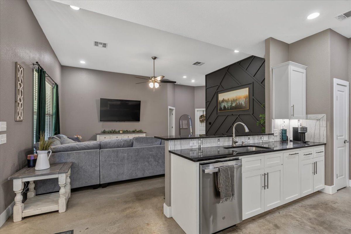 145 Cardinal Loop Paige, TX 78659 - Photo 12 of 40 An open concept living area boasts soaring vaulted ceilings, ample natural light, and sleek concrete floors.