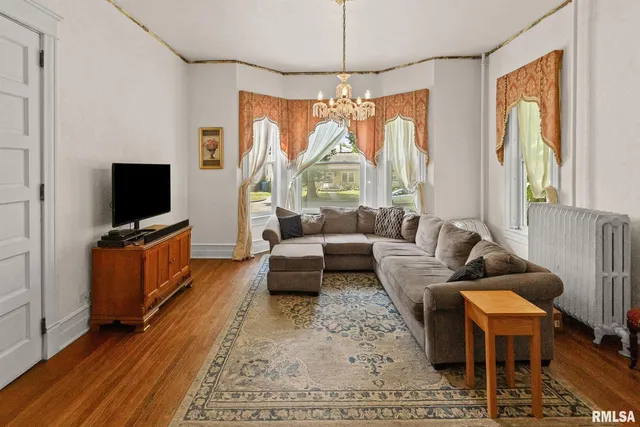 a living room with fireplace furniture and a chandelier