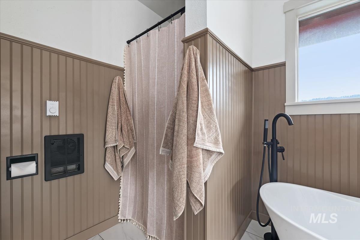 6 East Beck Road Garden Valley, ID 83622 - Photo 13 of 44 Full bathroom with a soaking tub, wooden walls, a wainscoted wall, and a shower with shower curtain