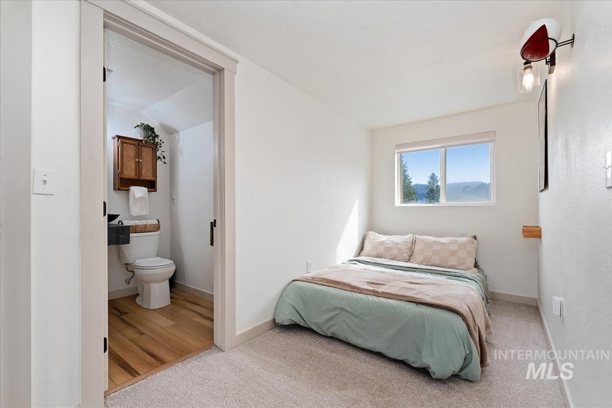 6 East Beck Road Garden Valley, ID 83622 - Photo 18 of 44 Bedroom featuring light carpet, connected bathroom, and light wood-style floors
