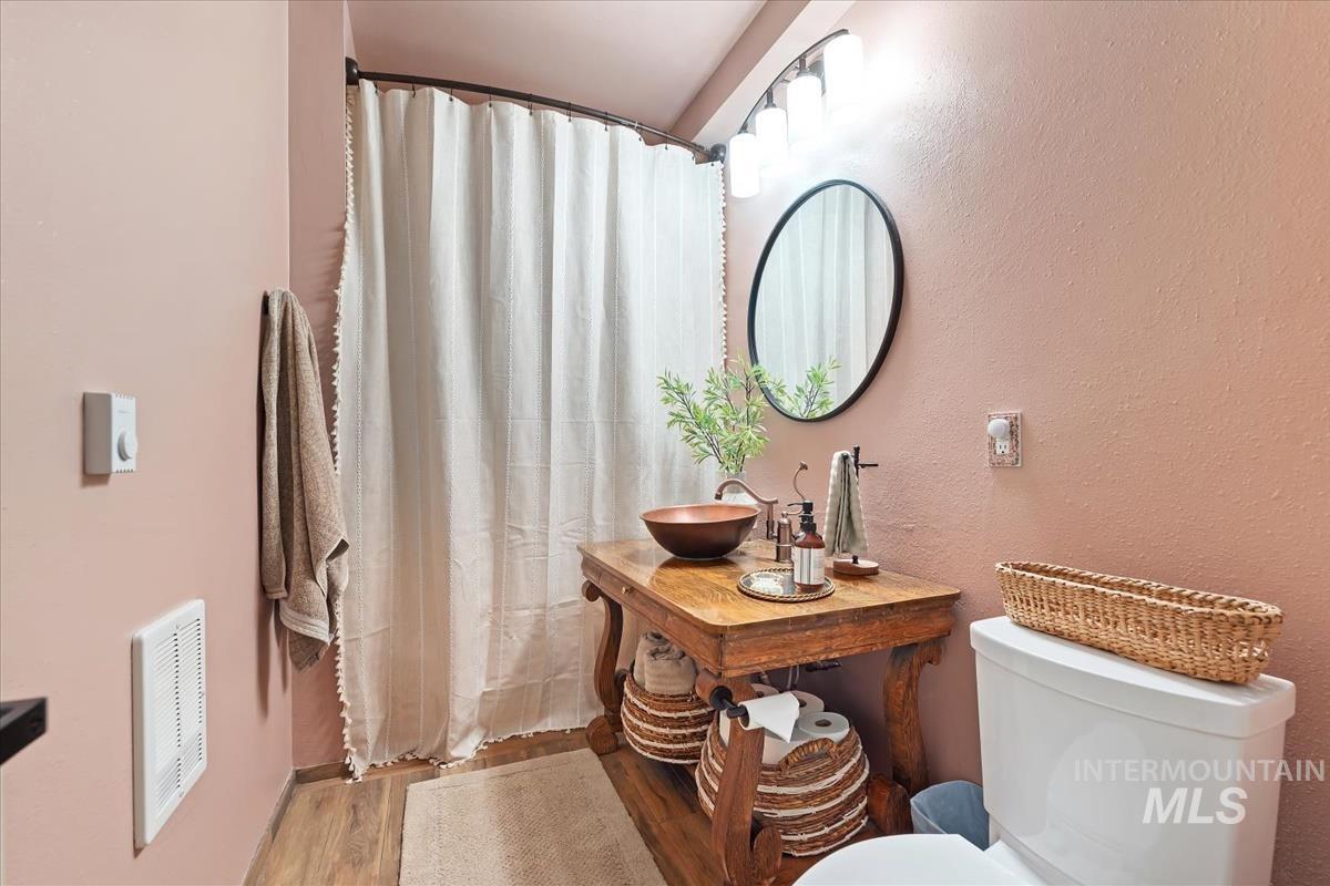 6 East Beck Road Garden Valley, ID 83622 - Photo 22 of 44 Full bathroom with wood finished floors, vanity, a textured wall, and a shower with shower curtain