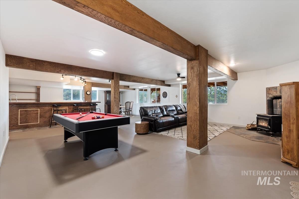 6 East Beck Road Garden Valley, ID 83622 - Photo 27 of 44 Recreation room featuring a wood stove, concrete floors, billiards, beam ceiling, and bar