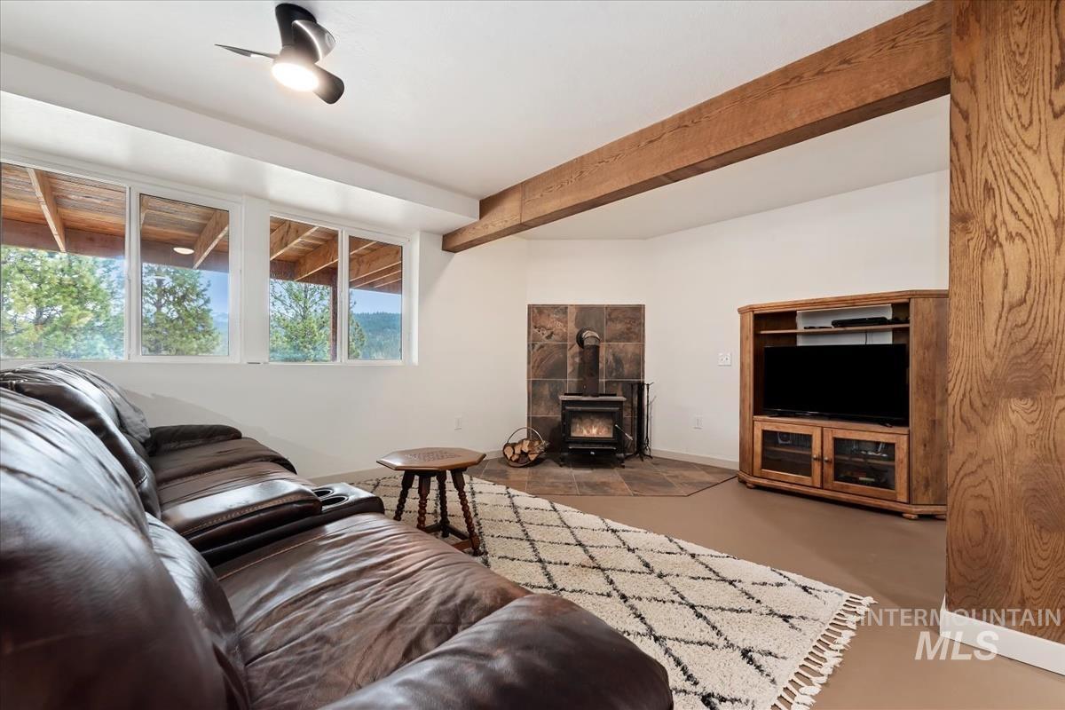 6 East Beck Road Garden Valley, ID 83622 - Photo 28 of 44 Living room with finished concrete floors, a wood stove, and beam ceiling