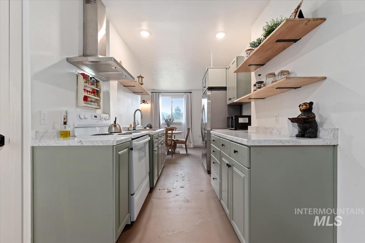 6 East Beck Road Garden Valley, ID 83622 - Photo 33 of 44 Kitchen featuring open shelves, light countertops, range hood, electric range, and concrete flooring