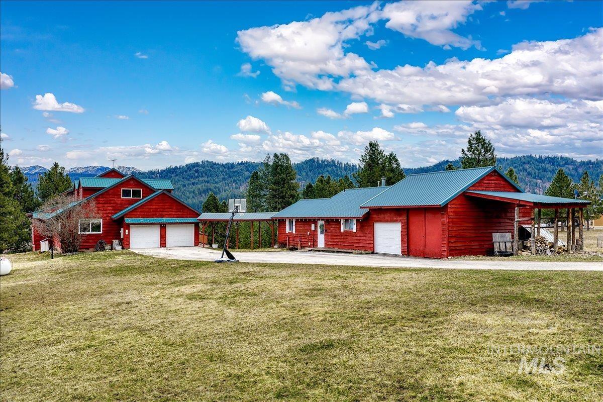 6 East Beck Road Garden Valley, ID 83622 - Photo 40 of 44 View of front of home featuring a front lawn, a mountain view, an attached garage, concrete driveway, and a metal roof