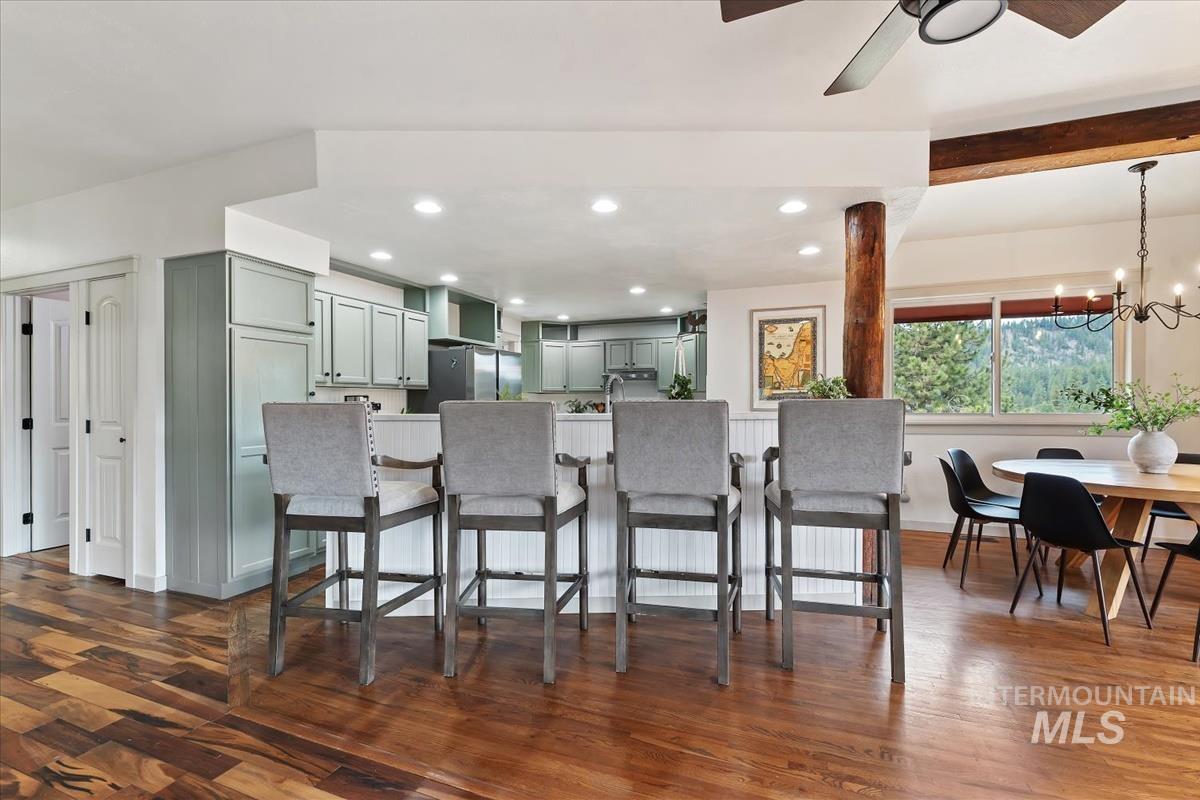 6 East Beck Road Garden Valley, ID 83622 - Photo 6 of 44 Kitchen featuring a breakfast bar area, dark wood-type flooring, a ceiling fan, a chandelier, and green cabinets