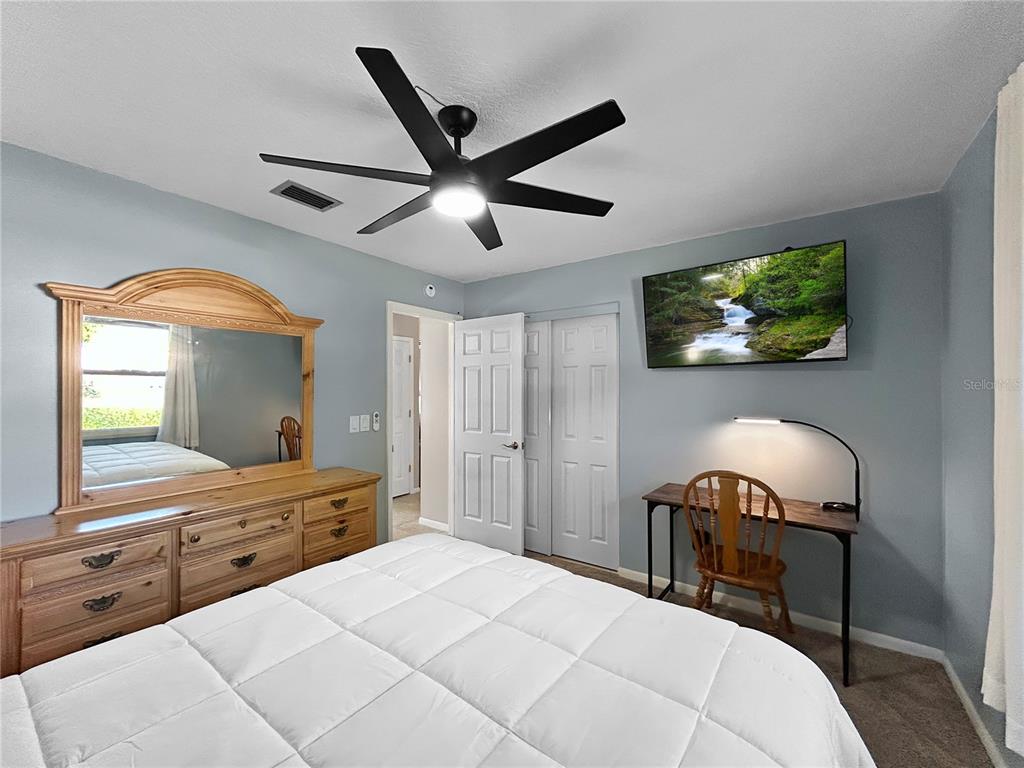 136 Paul Revere Road Bartow, FL 33830 - Photo 11 of 17 a bedroom with a bed and a chandelier with a flat tv screen