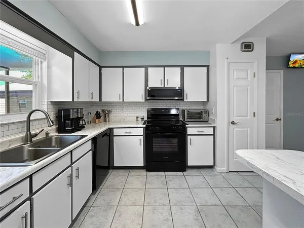 a kitchen with a sink appliances and cabinets