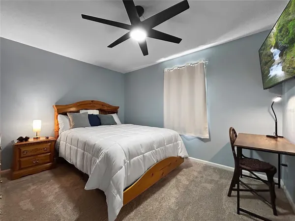 a bedroom with a bed a chandelier and a chair